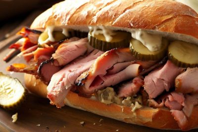 Roasted Pork and Ham Sandwich with Pickles and Mayo on a Baguette